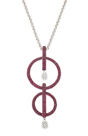 A diamond and ruby necklace, the pendant composed of two ruby set discs, each with a ruby set...