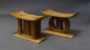 
	
		A pair of Ashanti style hardwood stools, mid 20th century, each with curving seat, with...