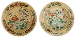 A pair of Chinese porcelain famille verte cafe au lait ground plates, Kangxi period, painted with floral sprays and rockwork, underglaze blue lotus mark within