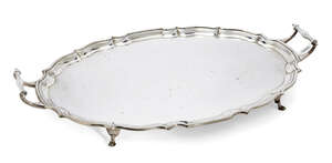 A twin-handled George V silver tray, Birmingham, c.1927, Barker Brothers, of shaped oval form with piecrust edge to plain base, the tray raised on four hoof fe