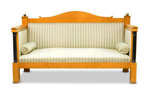 
	
		A Biedermeier birchwood and ebonised sofa, late 19th century, the shaped top above green...