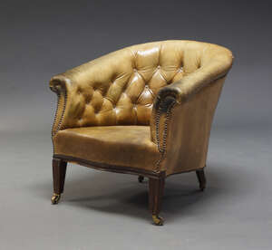 
	
		A Victorian button back tub armchair, upholstered in brown leather, raised on square...