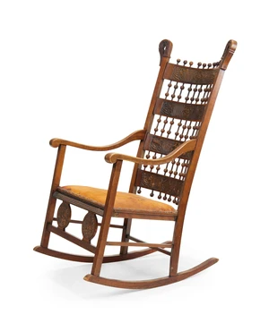 An Arts & Crafts walnut and beech rocking chair, last quarter 19th century, the spindle-centred ladderback applied with embossed leather panels to down-swept a