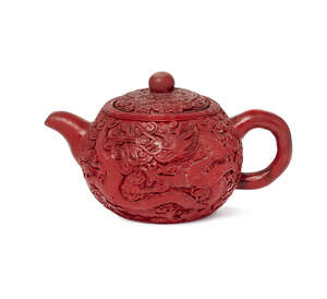 
	
		A Chinese red-lacquer encased yixing teapot, late Qing dynasty, carved to both sides with...