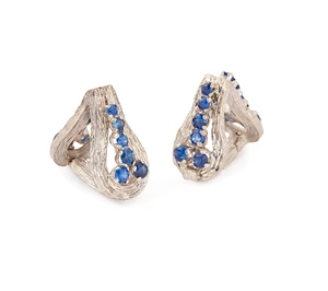A pair of sapphire stirrup cufflinks, set with circular mixed-cut sapphires, to an openwork...