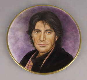 20th century School, a circular porcelain plaque of a portrait of a man, attributed to be Al Pacino, modelled with long flowing hair wearing a black coat and s