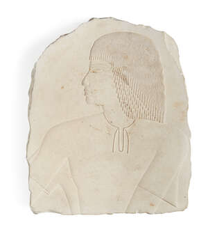 
	
		An Egyptian style limestone relief fragment with the profile bust of a male with well...