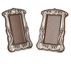 
	
		A matched pair of Art Nouveau silver and oak photograph frames
		Mark of Walker & Hall,...