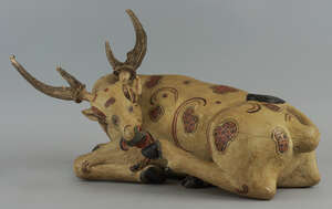 
	
		An Indian carved and painted model of a  seated cow, with horn antlers, 49cm...