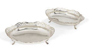 A pair of silver dishes with pierced galleries, Birmingham, c.1933, JPH, of shaped, oval form, each dish raised on four pad feet to plain base and sides, 19 x 