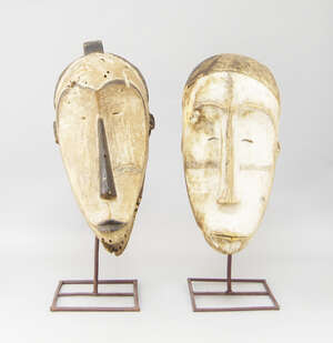 
	
		Two tribal masks, Fang, one double sided with elongated noses and pursed lips, 53cm high,...