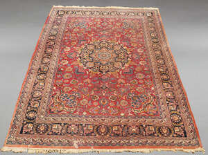 
	
		A large Persian woolen carpet, mid-20th century, the central reserve decorated with a...