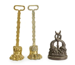 Three door stops, late 19th / early 20th century, comprising: a cast-iron example modelled as two up-turned cornucopia vases, 20cm high; and a pair of weighted