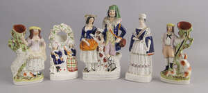 A Staffordshire pottery watch holder, 19th century, modelled with two Highland figures and a dog, 24cm high, together with a pair of Staffordshire spill vase f