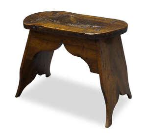 
	
		An English walnut and fruitwood vernacular stool, late 18th century, with shaped sides...