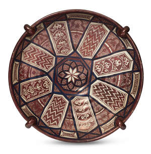A large Hispano Moresque plate, 19th century, with applied four ring form lugs to the rim, overall decorated with panels of geometric panelling, on scrolling p