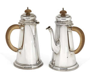 
	
		A bachelor's pair of silver café-au-lait pots, London, c.1928, Wakely & Wheeler, of...