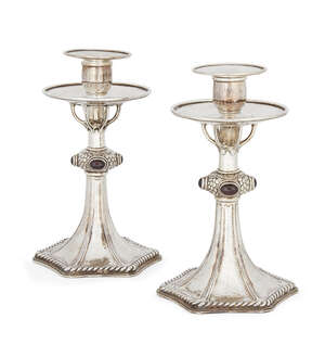 A pair of silver plated candlesticks in the manner of Omar Ramsden, the tapering stems to hexagonal bases with rope design border, the central knops decorated 