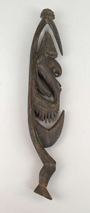 
	
		A Sepik flesh hook, carved and pierced with a male face with hooked nose, 51.5cm...