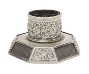 
	
		An octagonal based white metal inkwell, both the base and the well richly decorated with...