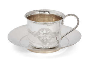 
	
		A bright-cut engraved cup and saucer, unmarked white metal, both decorated with flower...