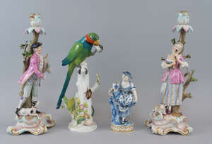 A pair of Meissen candle sticks, late 19th/early 20th century, modelled to the bases with a man playing a sacbut and a lady playing a flute, he in a pink coat 