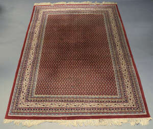 
	
		An Indian woollen carpet, mid-20th century, the central reserve densely decorated with...