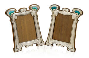 
	
		William Hutton & Sons, a pair of Arts and Crafts silver and enamel photograph frames
		