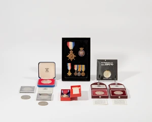 A display cased fitted with various medals and badges comprising: the 1914-15 Star, awarded to...