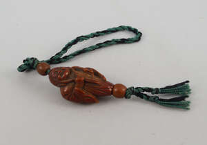 
	
		A Chinese nut bead, carved in the form of a sage, holding a ruyi sceptre, on a threaded...