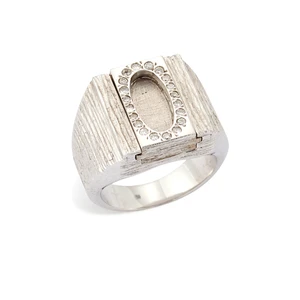 A diamond set locket ring, with hinged reversable mechanism, one side with oval shaped locket...