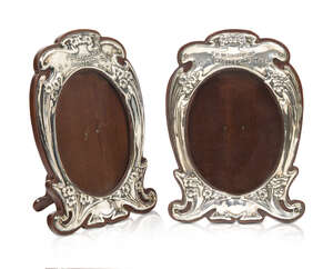 A pair of Art Nouveau silver photograph frames 
		Mark of J. Aitkin & Son, Birmingham hallmarks 1903, Rd. 413303
		The silver of shaped outline embossed with