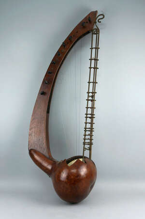
	
		An lyre form stringed instrument, possibly of African origin,  20th century, with a gourd...