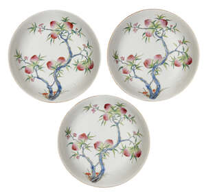 
	
		Three Chinese porcelain dishes, 19th century, each painted to the interior with a fruity...