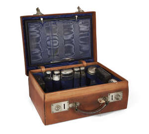 
	
		A leather travelling vanity case, fitted with hammered white metal mounted glass vanity...