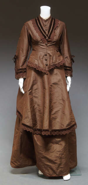 
	
		A 19th century ladies outfit, c.1870s, brown silk jacket, skirt and shawl, edged in brown...