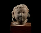 A fragmentary sandstone head, India, Gupta period, circa 4th century, 
with bulging almond...