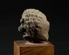 A fragmentary sandstone head, India, Gupta period, circa 4th century, 
with bulging almond...