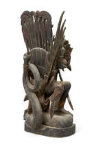
	
		A Balinese wood carving, early 20th century, carved as a wing deity attacking a dragon,...