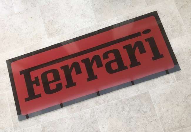 A Ferrari-themed Celluloid Garage-Type Wall Sign-Sold