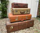 Selection of Four Well-Travelled Suitcases-Auction Lot
