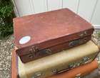 Selection of Four Well-Travelled Suitcases-Auction Lot