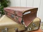 Selection of Four Well-Travelled Suitcases-Auction Lot