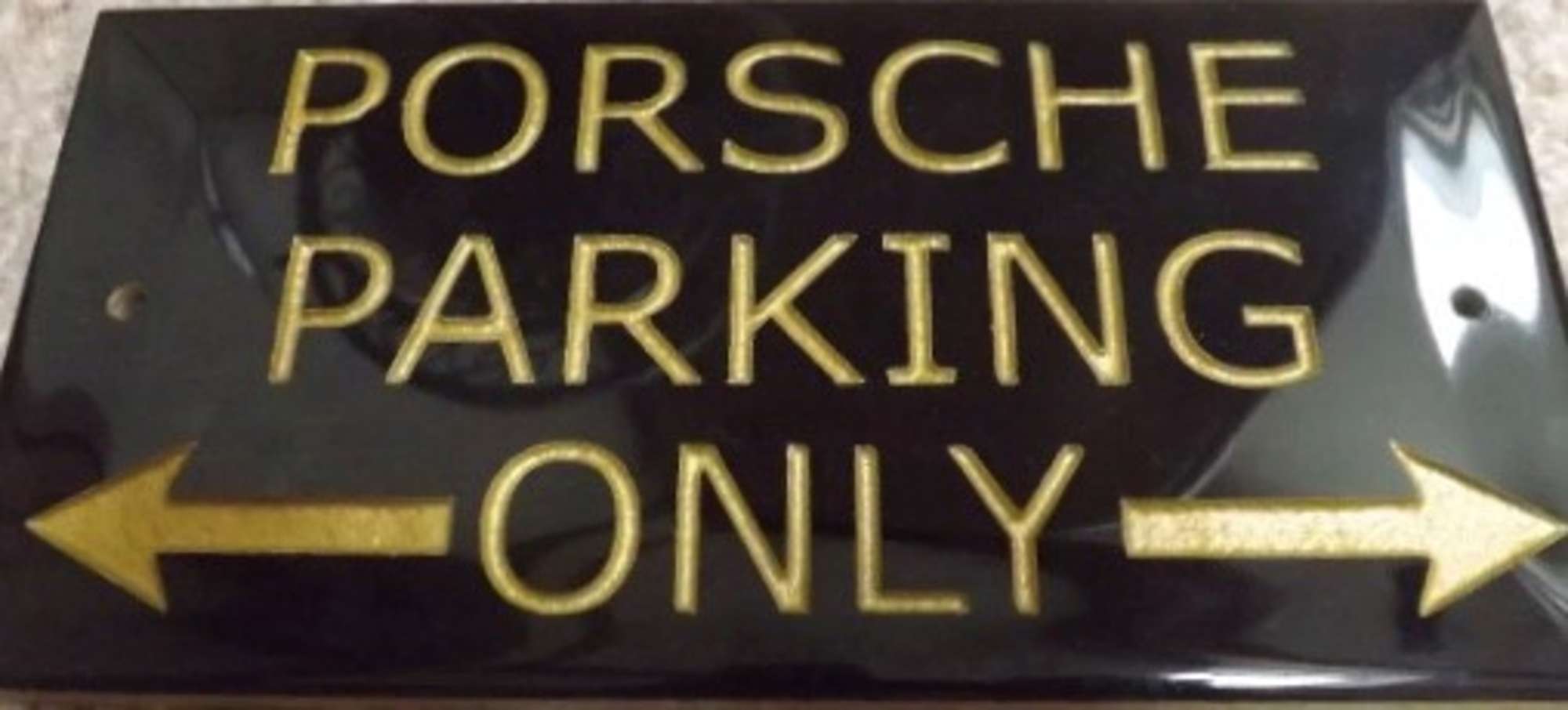 A ceramic tile in black ground with gold lettering  -Sold